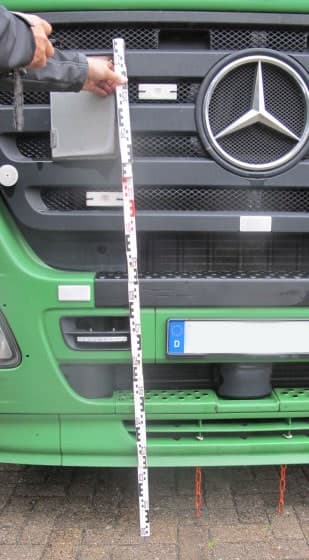 Messlatte vor der Front eines Mercedes-Lkw zur Bestimmung der Anstoßhöhe.